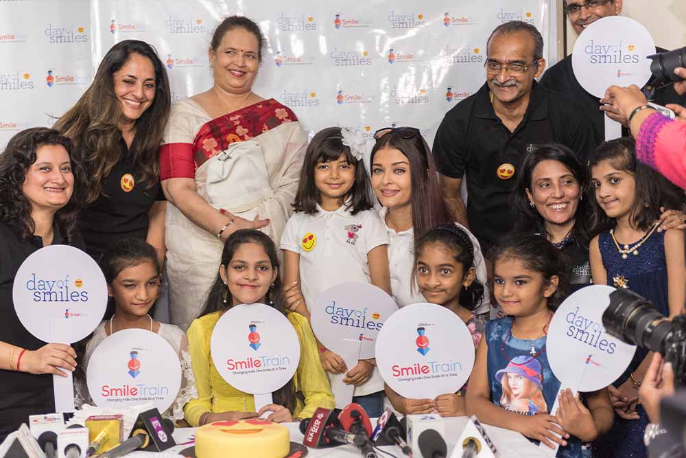 Aishwarya Rai Bachchan smiling with patients and Smile Train signs