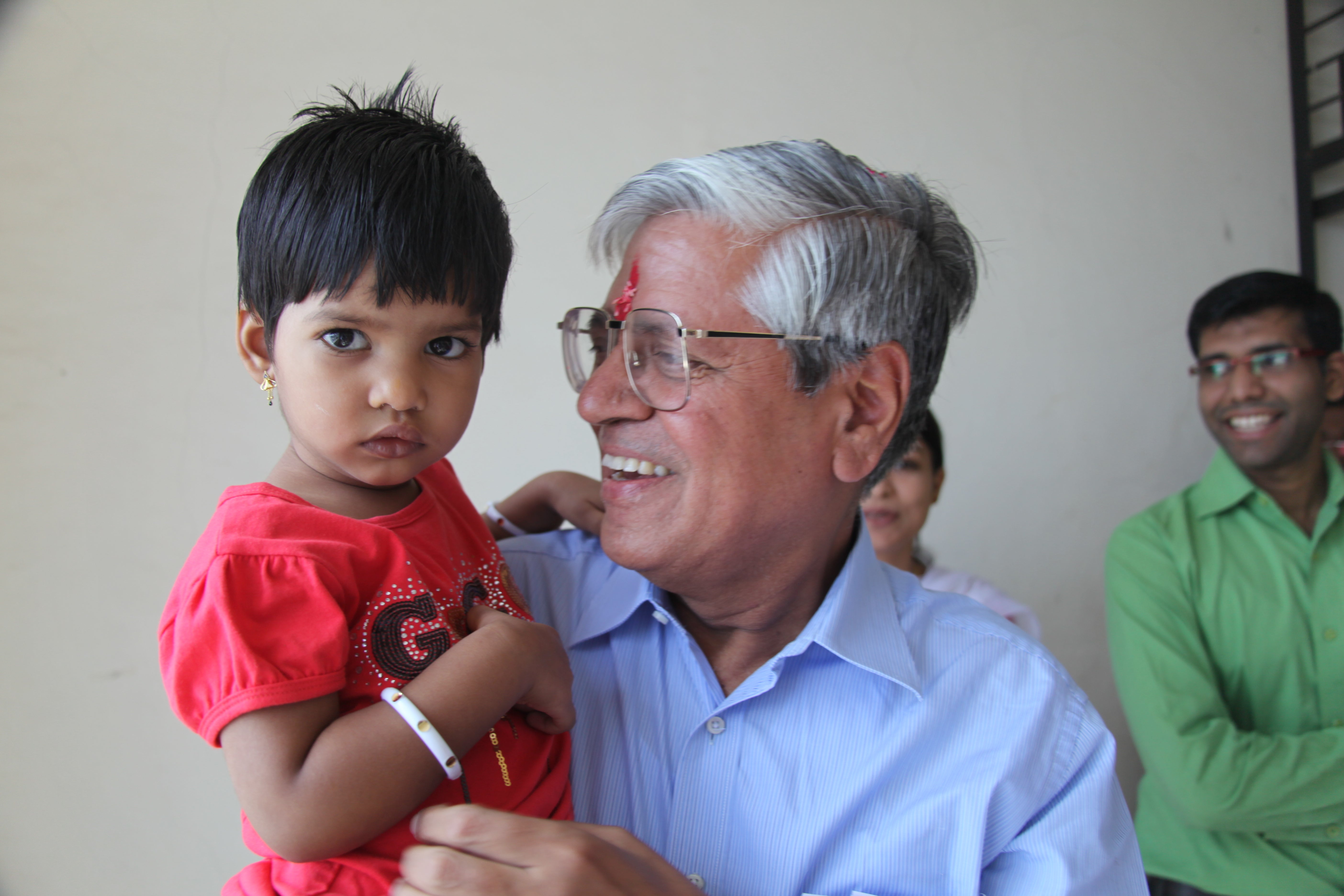 Dr. Satish Kalra smiling and holding a patient