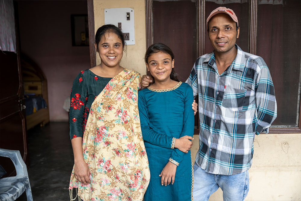 Paulwin smiling with her parents Rebecca and Prem after her cleft surgery