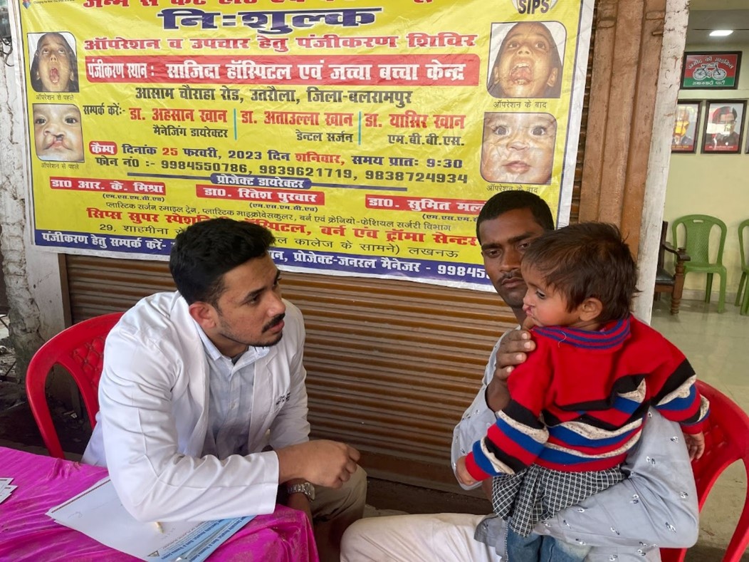 Dr Milen Mathew visiting with a patient and their father