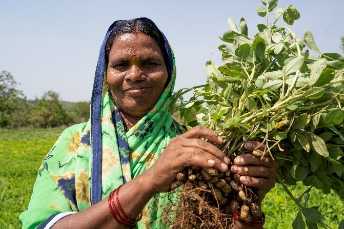 Surekha smiling and holding herbs after cleft surgery