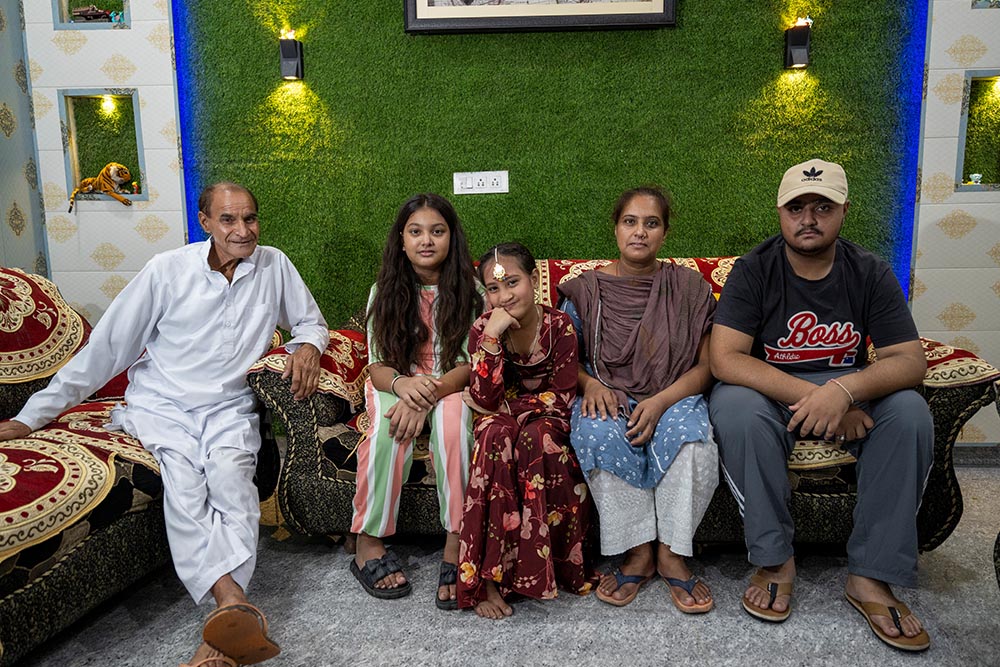 Bhumika smiling and sitting with her grandfather, sister, mother Jyoti and brother after cleft surgery