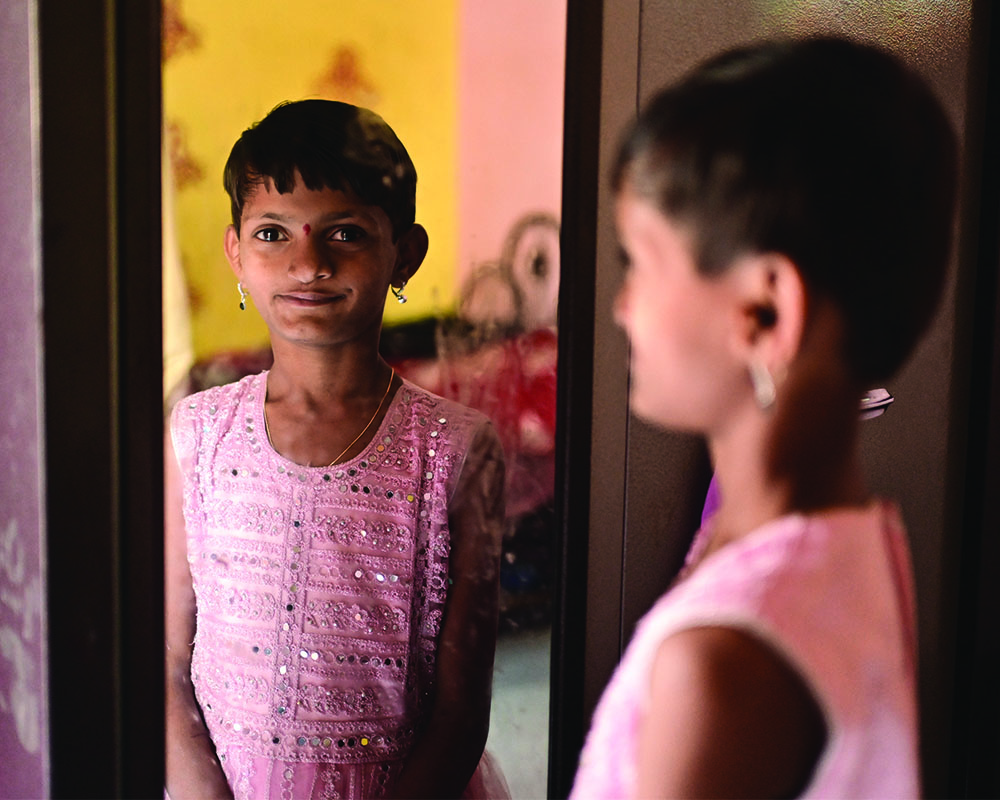 Yashoda confidently looking at her reflection in the mirror – and her newfound smile