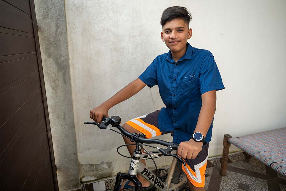 Swastik smiling and riding a bike after cleft surgery