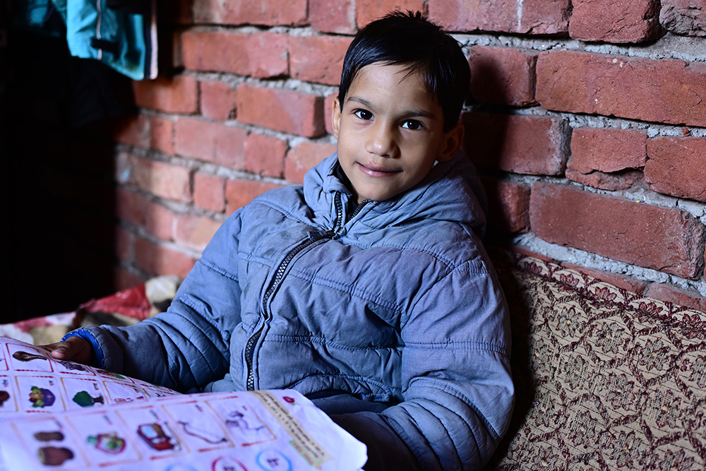 Hussain smiling and studying a book after cleft surgery