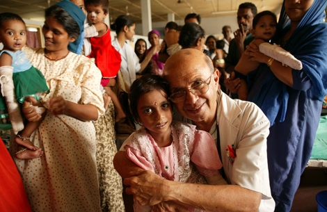 Dr. Adenwalla smiling and hugging a patient