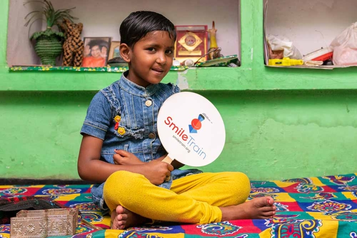 Saraswati holds a Smile Train fan