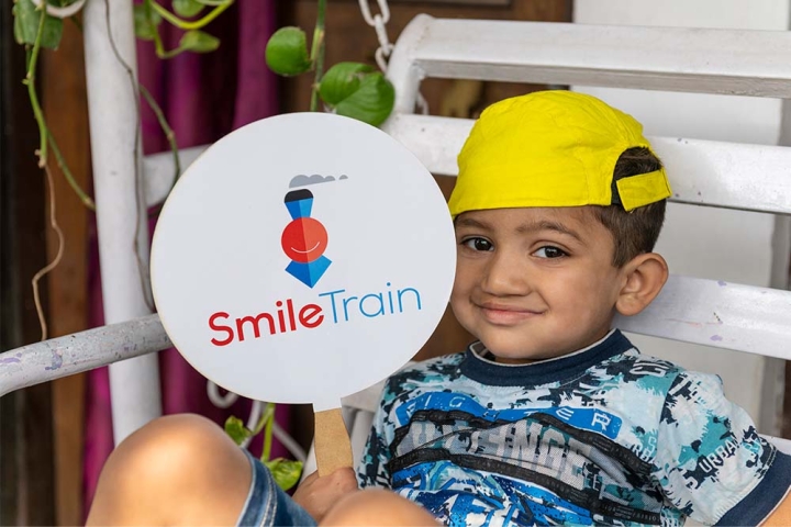 boy holds smile train sign
