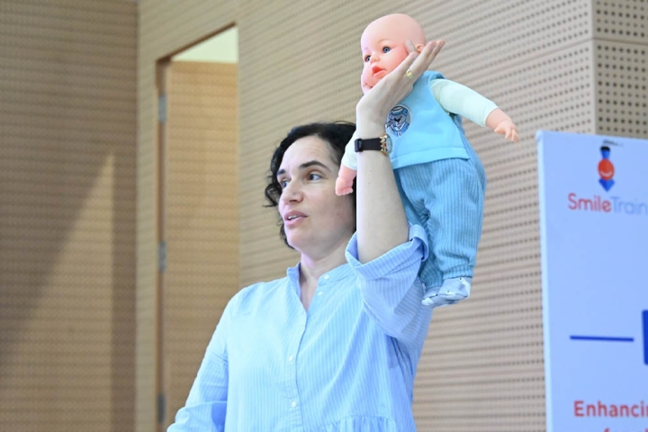 Barbara Delage giving a demonstration with a baby doll