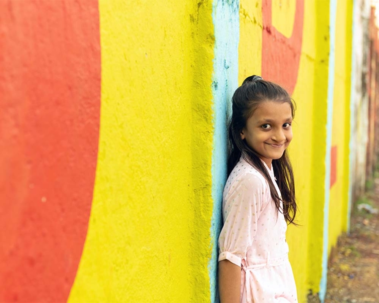 Humera smiling and leaning against a wall after cleft surgery