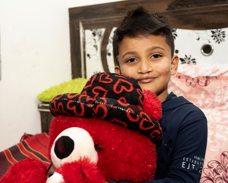 Abhay smiling with a teddy bear after cleft surgery