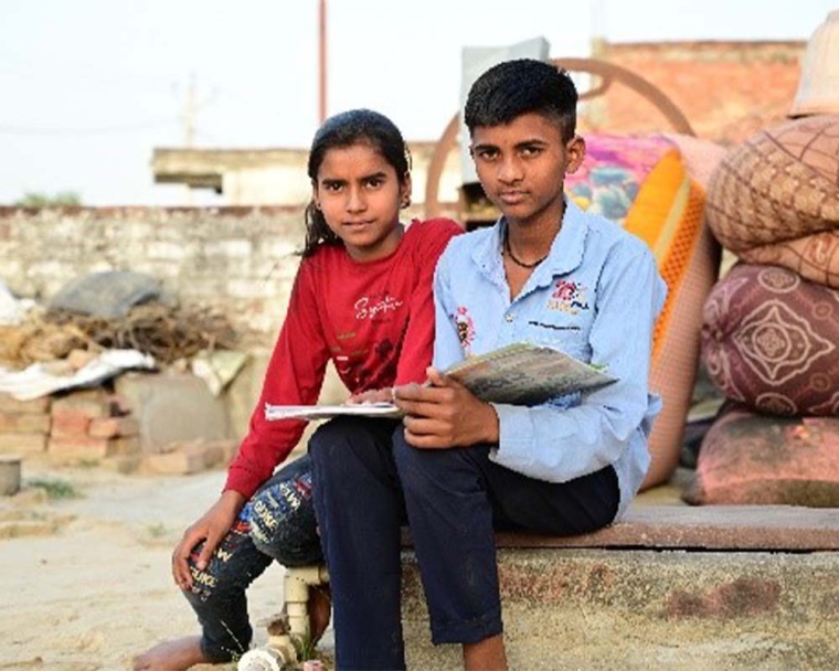 Monu sitting and holding a book after cleft surgery